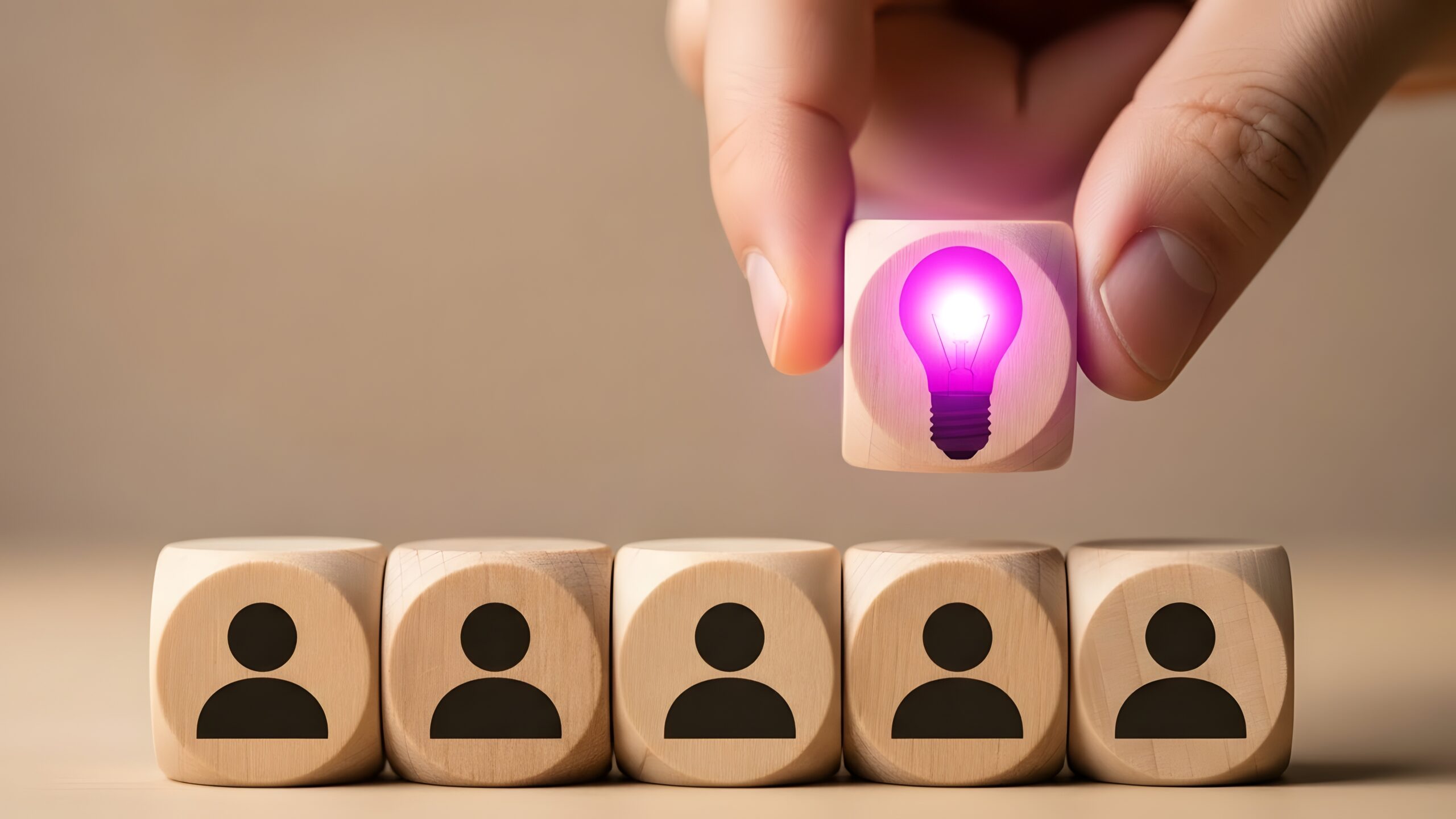 Hand Selecting A Glowing Idea Block Above A Row Of Human Resource Icons